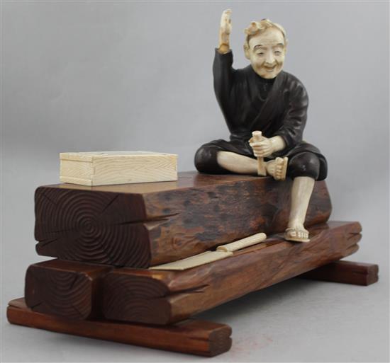 A Japanese ivory, bronze and wood okimono of a carpenter, early 20th century, 32.5cm., some losses